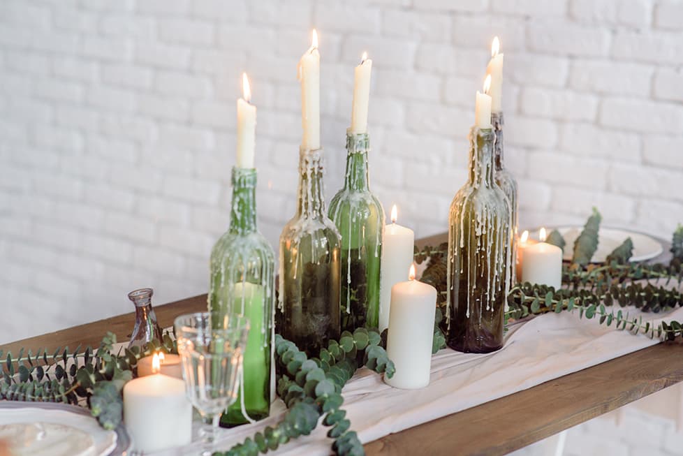 modern candle lit table setting with wine bottles