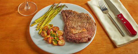 pan-seared ribeye steak with roasted garlic potatoes and asparagus